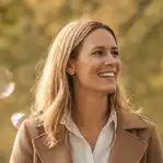 Beige Lederjacke mit goldenen Knöpfen und schwarzem Futter.