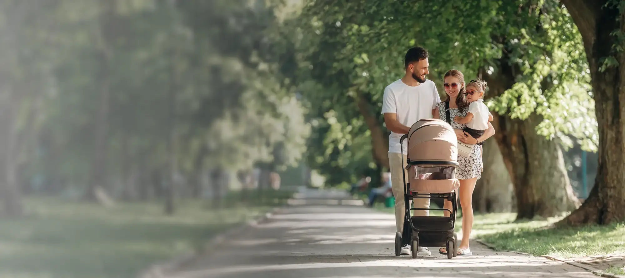 Kinderwagen mit pinken und beigen Akzenten, schwarzem Rahmen und modernem Design.
